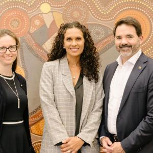 Three people in front of art work