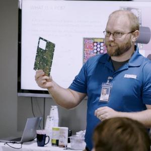 Presenter showing off circuit board