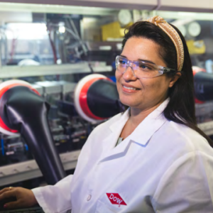 A person in white lab coat smiling to the side.