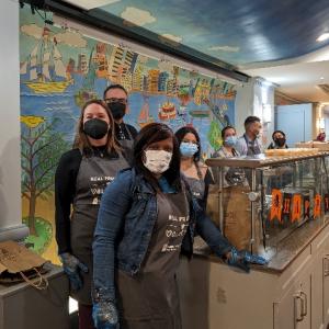 A group of volunteers posed wearing matching aprons.