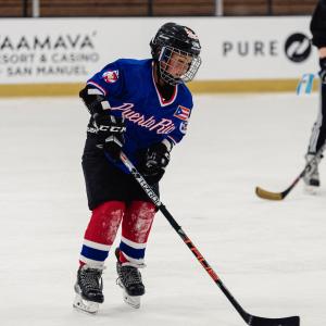A child from 24 Degrees of Color plays on the ice in a jersey representing his heritage. Photo credit: Jason C Williams Photography