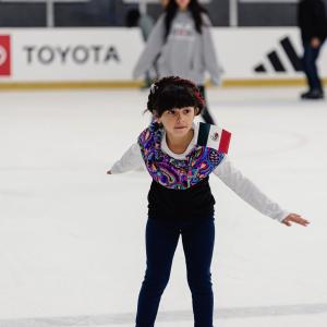A young girl from 24 Degrees of Color skates on the ice in an outfit representing her heritage. Photo credit: Jason C Williams Photography