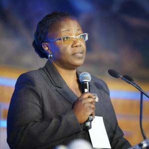 Dr. Jeanne d’Arc Mujawamariya speaks at a lectern on stage.