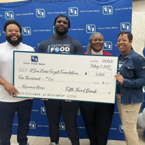 Four people holding a large Fifth Third Bank check