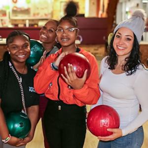Rebecca shown with two mentees at a bowling alley.