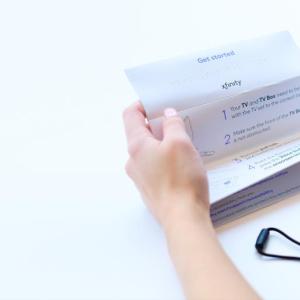 Person holding a remote and instructions 