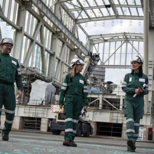 Three workers speaking together while walking