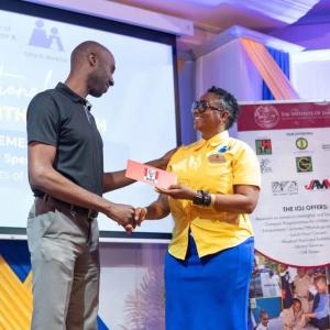 Restaurants of Jamaica Brand Manager Andrei Roper (left) presents a symbolic cheque to National Child Month Committee Chairperson Nicole Patrick-Shaw, during the National Child Month Launch.