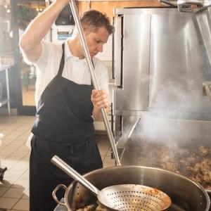 Chef preparing food at a stove.