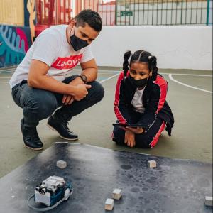 Two people looking at robot navigating blocks