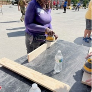 Aflac employee sanding a piece of wood