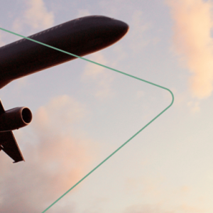 An airplane in the sky, a setting sun off screen.
