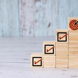 Wooden blocks with checked boxes stacked to mimic four steps