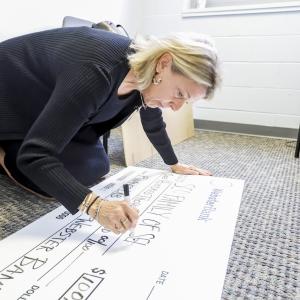 Grant check for $100,00.00 being made out by a representative from Webster Bank.