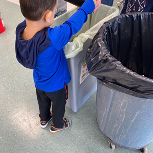 Small child emptying food waste into a bag