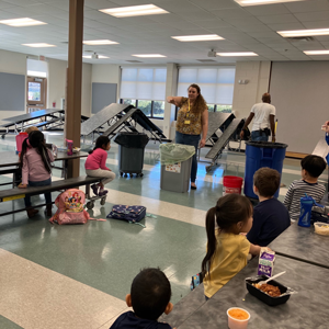 Young students sat at tables watching a demonstration