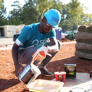 SEE employee pouring paint into a tray
