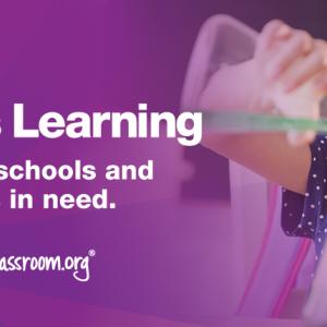 A child pouring liquid from one beaker to another. "Subaru Loves Learning helping schools and students in need"