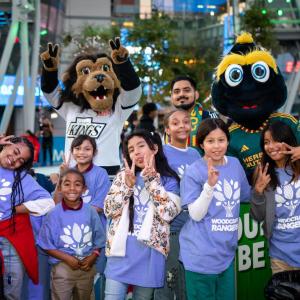 Children pose with LA Kings mascot Bailey and LA Galaxy mascot Cozmo at AEG's community holiday party at Peacock Theater at L.A. LIVE.