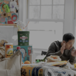 people in a kitchen unpacking a shopping bag