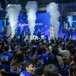 Students in audience watching people speaking on stage