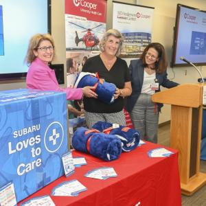 3 people presenting a blanket