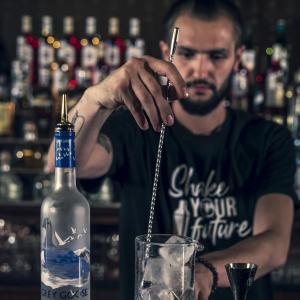 A bartender training  student mixing a drink