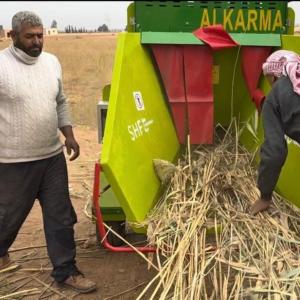 Ibrahim (left) uses the grinder provided by Action Against Hunger.