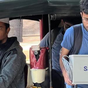 A person stepping out of a taxi carrying a Saafwater box.