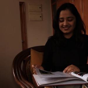 Sadbhavana Bhardwaj shown reading a book while seated at a table.