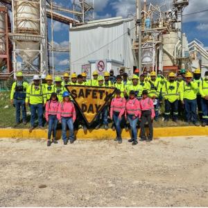 Group of employees stood around a sign that reads 'Safety day'