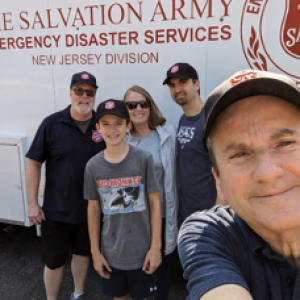 people smiling in front of Salvation Army vehicle