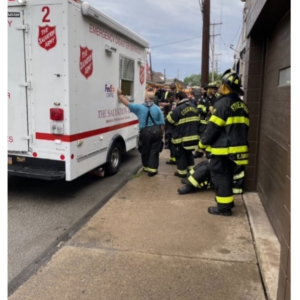 Fire personnel standing by a FedEx and Salvation Army truck