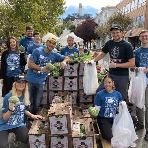 Volunteers pose with boxes of food at a food bank