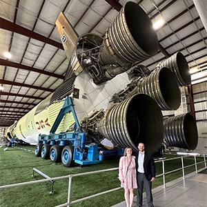Adam Sanders and partner Kasey Wilson in front of the Saturn V rocket at NASA's Johnson Space Center.