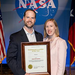 Adam Sanders and partner Kasey Wilson with the award Sanders received from NASA.