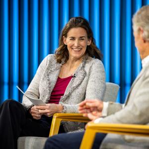 Sara Cronenwett and another seated on a stage.