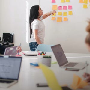 pointing to sticky notes on an idea board