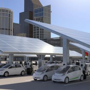 Electric cars pictured below solar panels and next to charging stations 