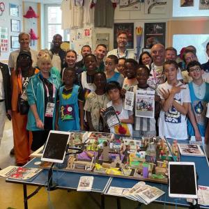 A large group photo of staff and students stood around a crafts table 