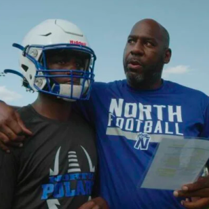 Coach with arm around football player