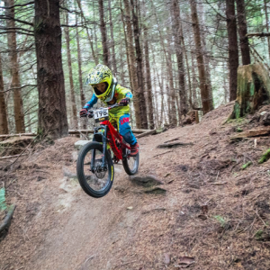 a child dirt biking in the woods