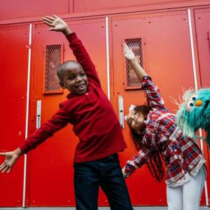Kids dancing with Sesame Street character