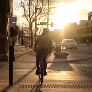 Richard McMichael riding his bike in a city at dawn