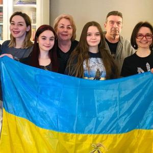 Sergii and family, some holding a Ukraine flag.