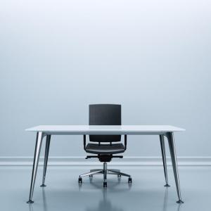Desk and chair in the center of an empty room