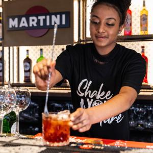 A person making a drink at a bar