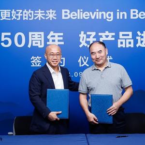 Two people stood together against a blue backdrop 