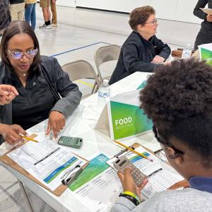 People fill out paper work using calculators