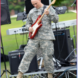 Shawn Mills, Principal Application Engineer, on stage playing the guitar 